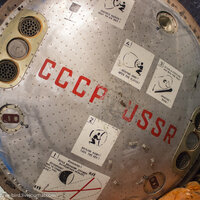 Задняя часть спускаемого аппарата с инструкциями на двух языках по открытию люка.