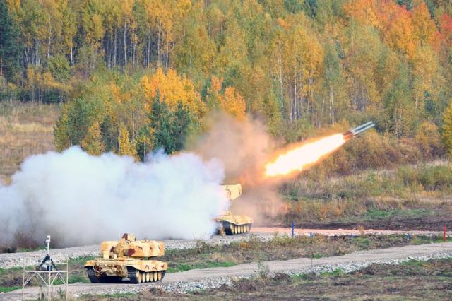 Огонь ведет боевая машина БМ-1, на переднем плане транспортно-заряжающая машина ТЗМ-Т тяжелой огнеметной системы ТОС-1А БМ-1 и ТЗМ-Т из ТОС-1А